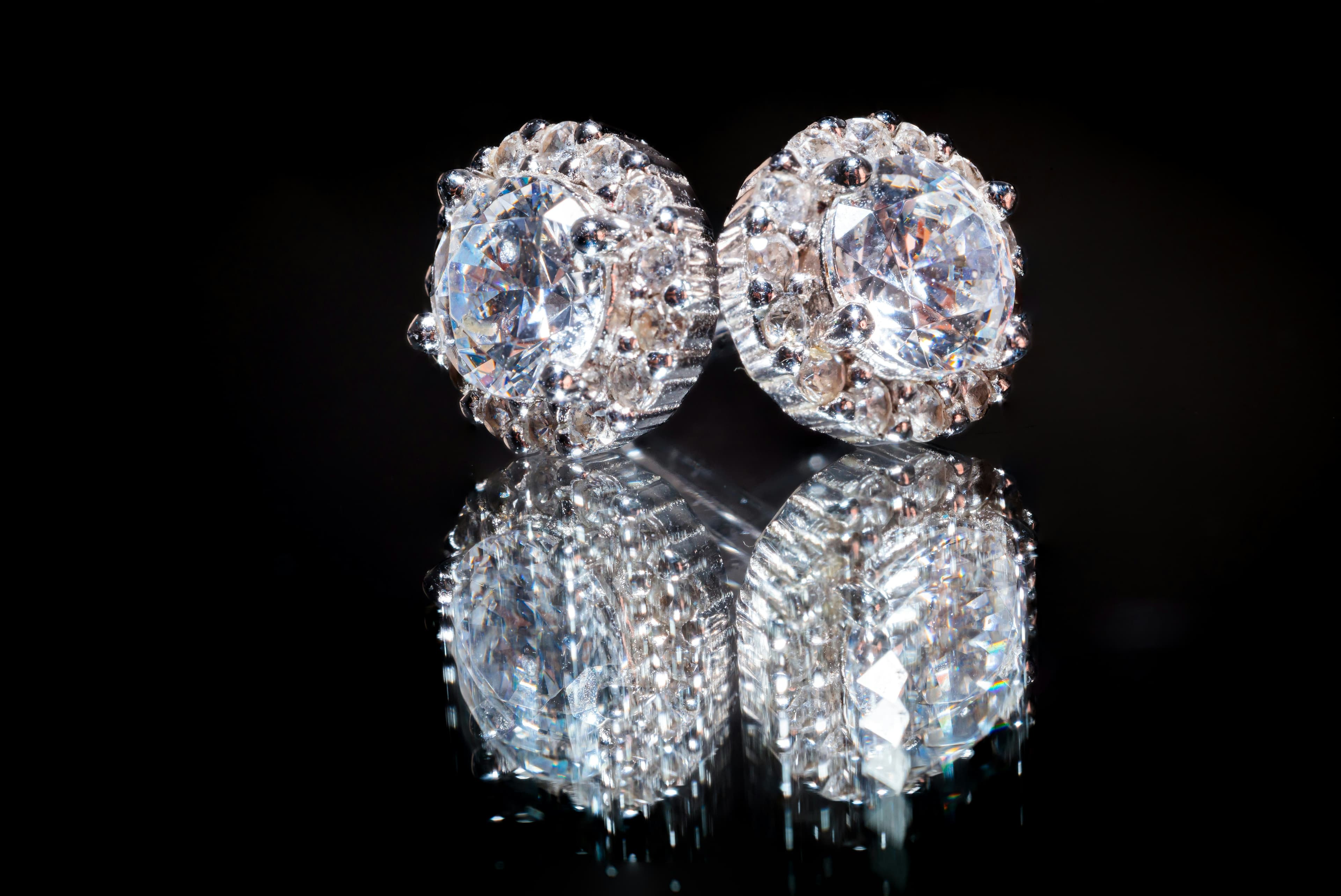 Diamant-Ohrringe auf reflektierender Oberfläche